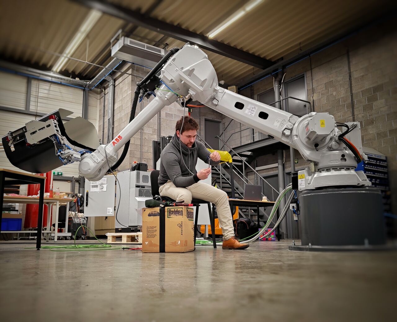 Ingenieur bedraadt een ABB-robot met grijper op maat in de werkplaats